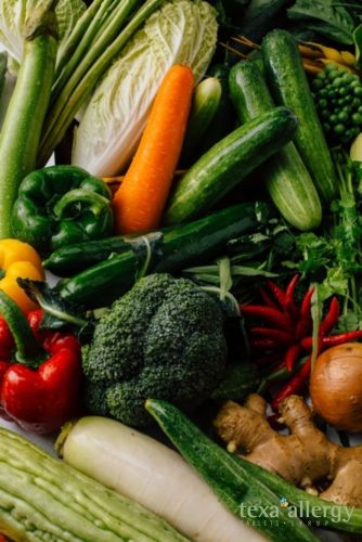 Stack of various healthy vegetables. witht he Texa Allergy logo int he bottom right corner.